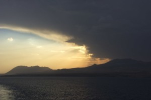 Die Strahlen des Sonnenuntergangs, wie sie sich gegen die dunkeln Gewitterwolken behaupten