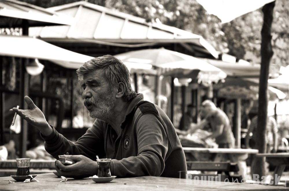Älterer Mann der in einer angeregten Unterhaltung steckt, Streetfotografie