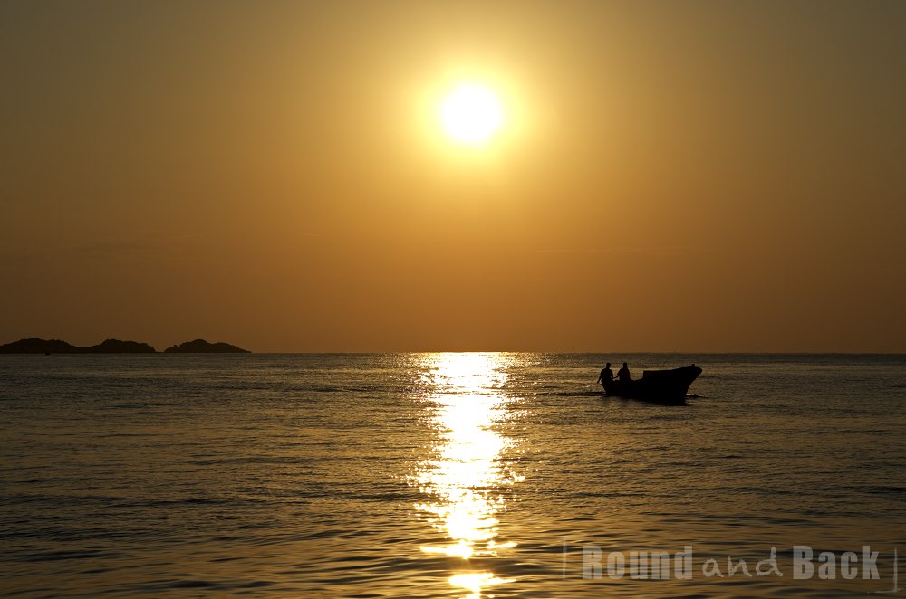 Zwei Fischer machen sich mit der aufgehenden Sonne auf den Weg zur Arbeit