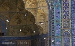 Isfahan, Tauben die grade davonfliegen, vor einer Wand der Moschee