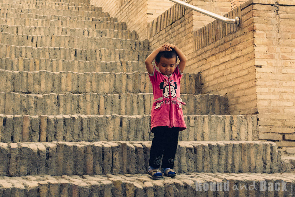 Junges Mädchen, das auf einer Treppe steht. Samarkand, Usbekistan.