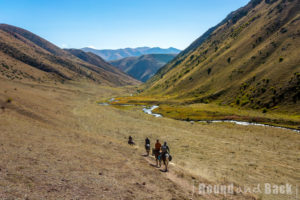Unsere Gruppe wie sie entlang des Flusses in die Berge reitet
